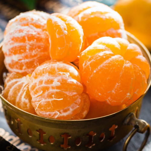 close up of tangerines in a bowl